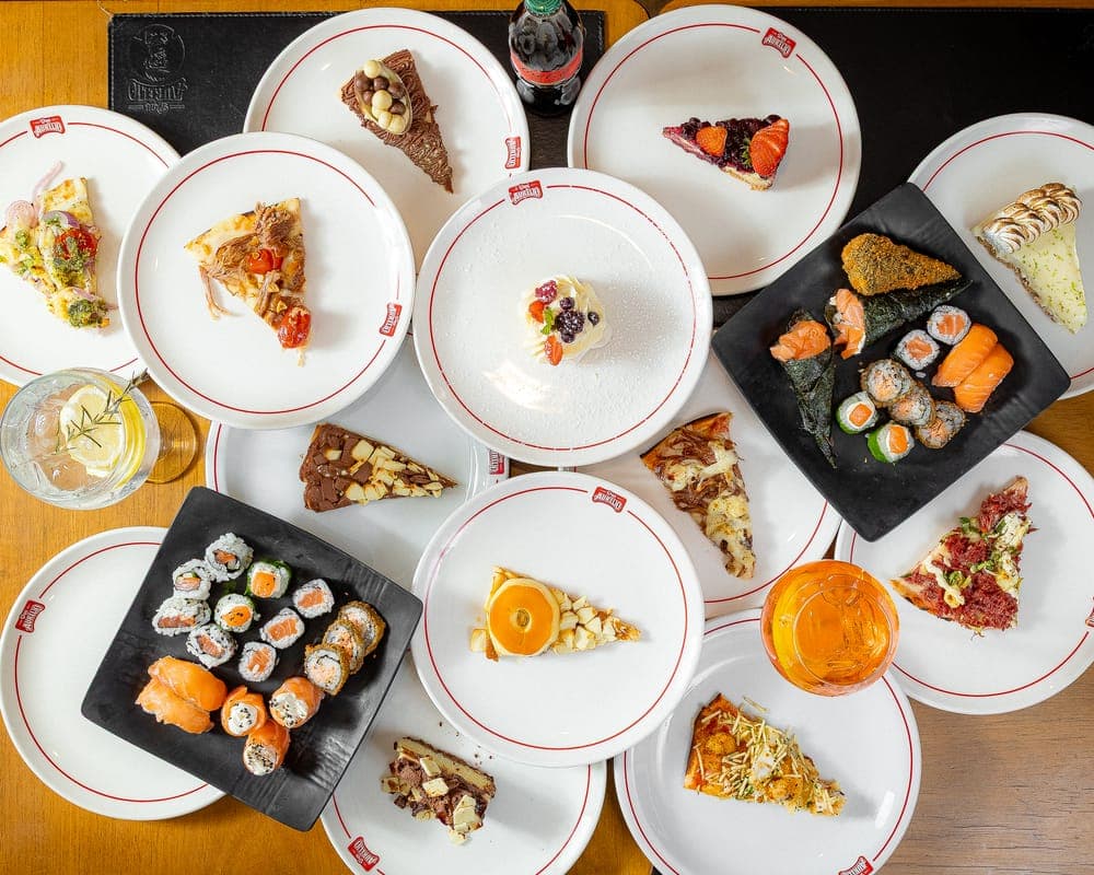 Mesa do rodízio com pizzas, sushis e sobremesas da Don Aurélio